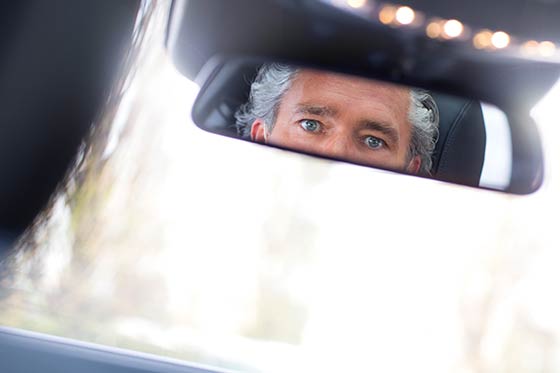 Die Augen eines Chauffeurs im Rückspiegel.